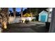 Cozy patio with white fence, table, chairs, and yellow umbrella surrounded by palm trees at nighttime at 613B 3Rd Ave. S, North Myrtle Beach, SC 29582