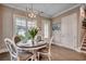 Dining area features a stylish chandelier, a round table with seating for four, and elegant crown molding details at 620 Lorenzo Dr. # 620, North Myrtle Beach, SC 29582