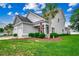 Charming two-story home featuring a landscaped yard, attached garage, and a welcoming front porch with an American flag at 620 Lorenzo Dr. # 620, North Myrtle Beach, SC 29582