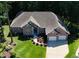 Aerial shot of brick home featuring an attached garage, beautiful landscaping, and lush, mature trees, perfect for serene living at 6572 Wellington Dr., Murrells Inlet, SC 29576