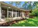The screened-in patio area features a grill, seamlessly blending indoor comfort with outdoor living in a lush backyard setting at 6572 Wellington Dr., Murrells Inlet, SC 29576