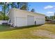 Spacious three car garage, with a gravel driveway and adjacent yard at 6593 Sunshine St. Nw, Ocean Isle Beach, NC 28469
