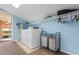 Bright laundry room with modern washer and dryer, storage shelves, and a skylight at 6593 Sunshine St. Nw, Ocean Isle Beach, NC 28469