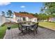 Outdoor patio featuring stone pavers, a dining set, and views of the grassy backyard and house at 6593 Sunshine St. Nw, Ocean Isle Beach, NC 28469