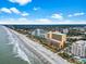 Beautiful aerial view of beachfront condos along a sandy shore with blue skies at 6900 North Ocean Blvd. # 938, Myrtle Beach, SC 29572