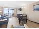 Living area with a dining table, seating, a TV, and a sliding glass door to the balcony with ocean view at 6900 North Ocean Blvd. # 938, Myrtle Beach, SC 29572