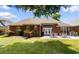 Brick home exterior with a patio featuring outdoor seating, overlooking the landscaped backyard at 702 Compass Point Dr., North Myrtle Beach, SC 29582