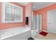 Bright bathroom featuring a soaking tub with glass block window and a glass enclosed shower at 702 Compass Point Dr., North Myrtle Beach, SC 29582