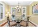 This dining area features a glass table, seating for four, and natural light from the surrounding windows at 702 Compass Point Dr., North Myrtle Beach, SC 29582