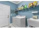 Well-organized laundry room with shelving, washer, dryer, utility sink, and a door at 702 Compass Point Dr., North Myrtle Beach, SC 29582