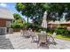Spacious backyard stone patio offers an umbrella-shaded dining area amidst lush greenery at 702 Compass Point Dr., North Myrtle Beach, SC 29582
