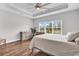 Bright main bedroom featuring tray ceilings, wood-look floors, and large windows with a view of the outdoors at 7377 Pauley Swamp Rd., Conway, SC 29527