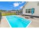 Outdoor pool with concrete patio, black metal safety fence, and chairs with umbrella at 7377 Pauley Swamp Rd., Conway, SC 29527