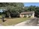 Charming single-story home featuring a red front door and a well-maintained yard and mature tree at 7708 Woodland Dr., Myrtle Beach, SC 29572