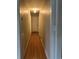 Hallway with hardwood floors and neutral-colored walls, providing access to various rooms at 7708 Woodland Dr., Myrtle Beach, SC 29572