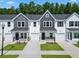 Charming townhomes showcasing a blend of gray and white exteriors, complemented by lush greenery and private driveways at 776 Nw Palm Frond Way # 55, Calabash, NC 28467