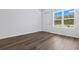 Bright living room featuring wood-look flooring, a window and white walls at 776 Nw Palm Frond Way # 55, Calabash, NC 28467