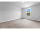 The bright, neutral-carpeted bedroom is illuminated by natural light from a window, complementing its light-colored walls at 786 Nw Palm Frond Way # 51, Calabash, NC 28467