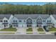 View of modern townhomes with garages, landscaped lawns, and dark-colored vehicles parked in driveways at 786 Nw Palm Frond Way # 51, Calabash, NC 28467