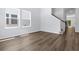 Bright living room featuring wood floors, large windows, and staircase with wood railing at 786 Nw Palm Frond Way # 51, Calabash, NC 28467