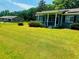 View of the home, lush lawn, and covered front porch, with another house in the background at 8 Raymond St., Andrews, SC 29510