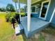 Spacious front porch with columns, steps, black railing, and partial view of the home at 8 Raymond St., Andrews, SC 29510