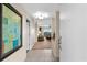 Inviting hallway leading into a living area with an artful painting and contemporary light fixture at 8121 Amalfi Pl. # 4706, Myrtle Beach, SC 29572