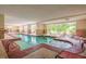 Inviting indoor pool area with lounge chairs and large windows overlooking lush landscaping providing a relaxing retreat at 8121 Amalfi Pl. # 4706, Myrtle Beach, SC 29572