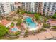 Aerial view showcasing the resort's large swimming pool area with ample seating, hot tubs, and lush landscaping at 8121 Amalfi Pl. # 4706, Myrtle Beach, SC 29572