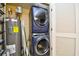 This laundry room includes a stacked washer and dryer set and a hot water heater at 8121 Amalfi Pl. # 7-805, Myrtle Beach, SC 29572