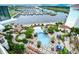 Aerial view of a pool surrounded by lounge chairs, greenery, and the marina in the distance at 8121 Amalfi Pl. # 7-805, Myrtle Beach, SC 29572
