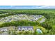 Aerial view showcases a townhome community with a pool, surrounded by lush greenery and trees at 837 Triple Ct. # 837, Myrtle Beach, SC 29588