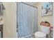Bright bathroom featuring a shower with blue leaf patterned curtain, vanity, and toilet at 837 Triple Ct. # 837, Myrtle Beach, SC 29588