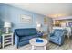 Inviting living room features a sofa, patterned chair, beach-themed artwork, and an open-concept layout at 9400 Shore Dr. # 124, Myrtle Beach, SC 29572