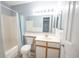 Bathroom with a single sink vanity, toilet, bathtub with curtain, and a large mirror at 1100 Possum Trot Rd. # H-233, North Myrtle Beach, SC 29582