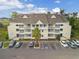 Aerial view of condo building with beige siding, multi-level balconies, and well-maintained landscaping and parking at 1100 Possum Trot Rd. # H-233, North Myrtle Beach, SC 29582