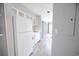 Bright kitchenette with white cabinets, appliances, tile backsplash and views to the living room at 1100 Possum Trot Rd. # H-233, North Myrtle Beach, SC 29582