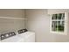 Well-lit laundry room with a window, shelf, and modern washer and dryer at 1120 Oak Meadow Dr., Conway, SC 29526