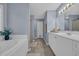 Bright bathroom featuring double vanity, large tub, tile flooring and neutral paint at 137 Maiden Ln., Myrtle Beach, SC 29588