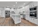 Bright, open-concept kitchen featuring white cabinetry, stainless steel appliances, and wood-look flooring at 1529 Bucksport Rd., Conway, SC 29527