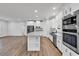 Bright, open-concept kitchen featuring white cabinetry, stainless steel appliances, and wood-look flooring at 1529 Bucksport Rd., Conway, SC 29527