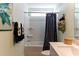 Clean white bathroom with shower-tub combination with blue pattern curtain and towel rack at 153 Stride Ct., Myrtle Beach, SC 29588