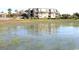 View of multi-story condo building from the water, reflecting in the foreground at 1582 South Waccamaw Dr. # 56, Garden City Beach, SC 29576