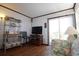 Bright living room featuring wood-look floors, a TV, and access to the balcony at 1582 South Waccamaw Dr. # 56, Garden City Beach, SC 29576