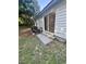 Rear concrete patio with sliding glass doors to enter home and a side yard area with trees at 1676 Citadel Ln., Myrtle Beach, SC 29577