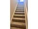 A carpeted staircase has neutral walls and a white banister leading to the next level at 1676 Citadel Ln., Myrtle Beach, SC 29577