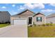 Charming single-story home featuring a manicured lawn, attached garage, and neutral siding with dark shutters at 1704 Perthshire Loop, Myrtle Beach, SC 29579