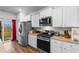 Modern kitchen with white cabinets, stainless steel appliances, granite countertops, and sliding glass doors at 1704 Perthshire Loop, Myrtle Beach, SC 29579