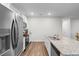 Bright kitchen with a stainless steel refrigerator, granite countertops, and a center island featuring a sink at 1704 Perthshire Loop, Myrtle Beach, SC 29579