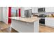 Bright kitchen featuring a center island with a sink, granite countertops, stainless steel appliances, and ample cabinetry at 1704 Perthshire Loop, Myrtle Beach, SC 29579